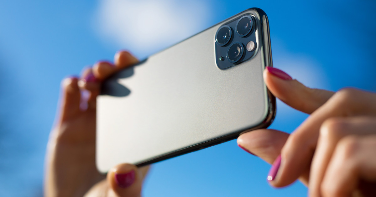 Woman holding up smartphone taking a picture